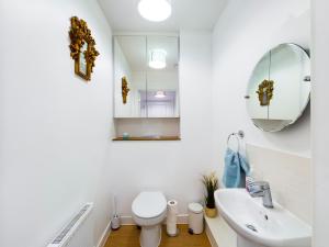 a bathroom with a sink and a toilet and a mirror at Cheerful 5-BDR/3-BATH House w/ Free Parking in Reading