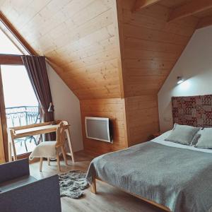 ein Schlafzimmer mit einem Bett, einem Stuhl und einem TV in der Unterkunft Domek na Ubocy z widokiem i sauną in Biały Dunajec