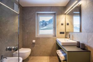 a bathroom with a toilet and a sink and a mirror at Apartments Armeri Blue Dolomites in San Vigilio Di Marebbe +23 photos