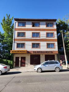 un edificio con un coche aparcado delante de él en Hotel Panoramico Bariloche en San Carlos de Bariloche