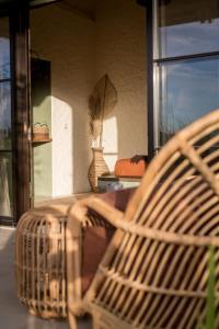 a wicker bench sitting in front of a window at Drop In Surf Lodge in Kuta Lombok