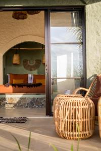 um quarto com uma cama e uma cadeira de vime em Drop In Surf Lodge em Kuta