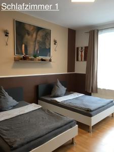 Un dormitorio con dos camas y un cuadro en la pared. en Ferienwohnung RIENA, en Riesa