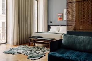 a bedroom with a bed and a couch and a rug at Hotel Hotel - Member of Design Hotels in Lisbon