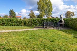 a park with a table and a grill in the grass at Ferienwohnungen Zum Fischerhafen in Freest