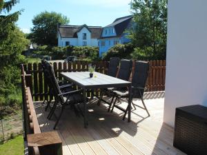 a wooden deck with a table and chairs on it at Ferienwohnungen Zum Fischerhafen in Freest