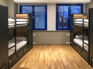 a room with three bunk beds and two windows at Generator Berlin Prenzlauer Berg in Berlin