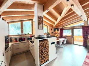a large kitchen with a counter with a pile of wood at Puitbach Chalet in Leutasch
