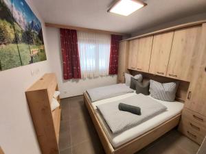 a small room with a bed and a cabinet at Puitbach Chalet in Leutasch