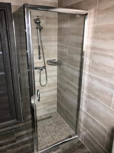 a shower with a glass door in a bathroom at ApartHotel in Mukacheve