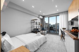 Cet appartement comprend une chambre avec un lit blanc et une cuisine. dans l'établissement The SkySphere, Nilie Hospitality MGMT, à Thessalonique