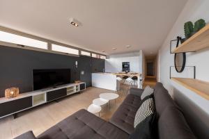 a living room with a couch and a large television at MEDANO4YOU Surfers Paradise Casa Medano in El Médano