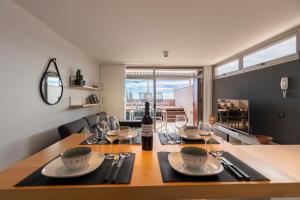 a dining room table with a bottle of wine and glasses at MEDANO4YOU Surfers Paradise Casa Medano in El Médano
