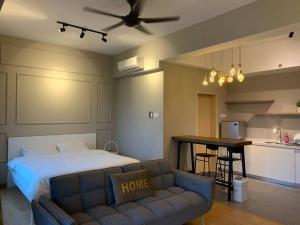 a bedroom with a bed and a couch and a kitchen at Kuantan Seaview Studio@Imperium Residence TgLumpur in Kuantan