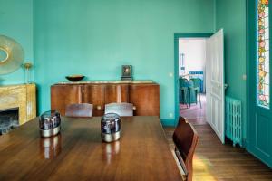 uma sala de jantar com uma mesa de madeira e paredes azuis em La Maison de Florence em Angers