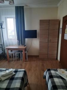 Zimmer mit 2 Betten, einem Tisch und einem Schrank in der Unterkunft Арт-готель "Династія" in Bila Zerkwa