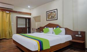 a bedroom with a large white bed with colorful pillows at The Elite Suites in Pune