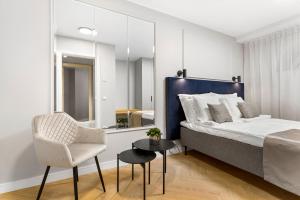 a bedroom with a bed and a chair and a mirror at Bob W Tallinn City Centre - Ambassador in Tallinn