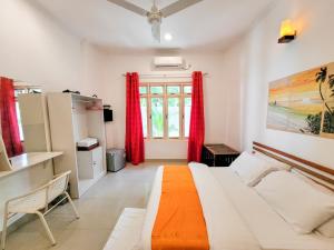 a bedroom with a bed and red curtains at Alesara Guest House in Thoddoo