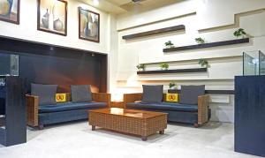 a lobby with two couches and a coffee table at The Elite Suites in Pune