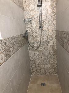 uma casa de banho com um chuveiro e piso em azulejo em Da Esterina appartamento sulla riviera del Brenta em Mira