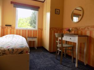 1 dormitorio con cama, escritorio y ventana en Kråkehaugen Feriehus, a perfect holiday retreat near Åheim, en Åheim