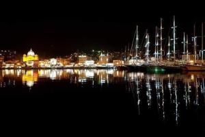 Akadimia Luxury Apartment في ميتيليني: إطلالة على ميناء في الليل مع قوارب في الماء
