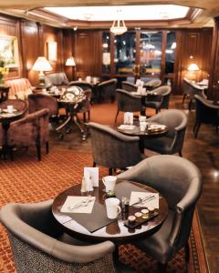 a restaurant with couches and tables and chairs at Hôtel Napoleon Paris in Paris