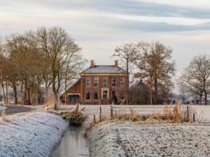 a large brick house with a river in front of it at Bed and Breakfast Batenborg in Winsum