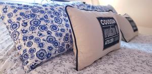 a bed with a pillow with a blue and white pattern at Le Vieux Moulin Gites - Detached cottage with garden views and pool in Guégon