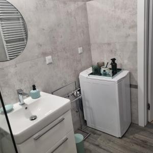 y baño con lavabo blanco y espejo. en Apartament Skarbowa, en Leszno