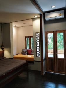 1 dormitorio con cama, ventana y espejo en Reun Sroyraya Boutique Home เรือนสร้อยระย้าบูทิค, en Ban Kok Sai