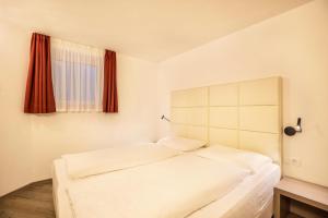 um quarto com 2 camas brancas e uma janela em Apartment Ön Residence Bun Ste em San Vigilio Di Marebbe