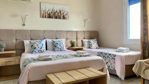 2 letti in una camera con 2 letti e vista sul giardino. di Pelineon Rooms a Chio (Chios)