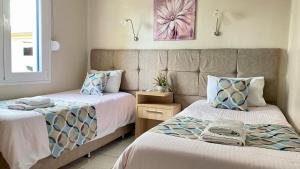dos camas sentadas una al lado de la otra en un dormitorio en Pelineon Rooms, en Chios