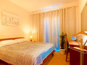 Nice-Comfort-Lux Apartment 95m2 near the beach في ميدولين: غرفة نوم بسرير ونافذة مع ستائر