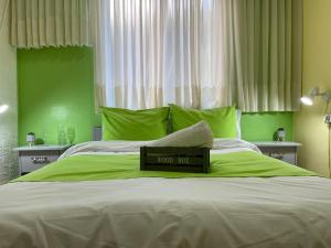 a green bedroom with a bed with a wooden box on it at Breezot Yam in Nahariyya