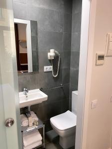 W łazience znajduje się umywalka, toaleta i lustro. w obiekcie BCN Urbaness Hotels Bonavista w Barcelonie