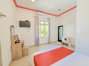 a white room with a bed and a television at Alesara Guest House in Thoddoo