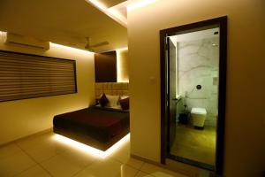 a bedroom with a bed and a mirror in a room at Hotel Hindustan Residency Thane in Thane