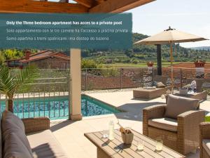 a patio with a pool and chairs and a table at Salinea Apartments in Sečovlje