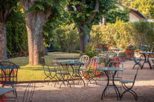 a group of tables and chairs in a park at Hôtel Le Donjon - Cœur de La Cité Médiévale in Carcassonne