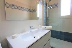 bagno bianco con lavandino e doccia di Appartamento nuovissimo climatizzato a 150 m dalla spiaggia a Lido Marini