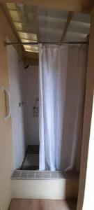 a bathroom with a shower with a white shower curtain at Migdal Oz aka Rufpatch in Smithfield +9 photos