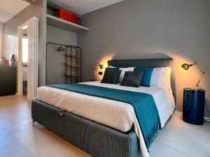 罗马RomeAsYouLike - Magenta Loft的卧室里有一张大床，配有蓝白相间的枕头