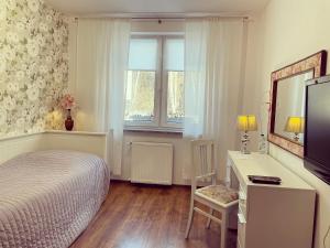 Dormitorio con cama, escritorio y TV en Gosciniec Pod Brzozami en Poznan