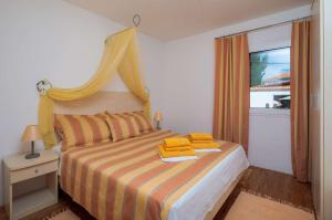een slaapkamer met een bed met gele kussens erop bij Apartment Oaza in Supetar