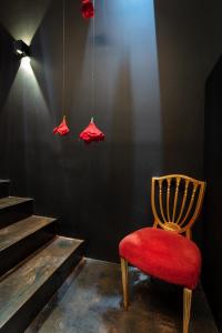 a red chair sitting in a room with stairs at Zrooms&Suites Hostel Boutique in Zaragoza