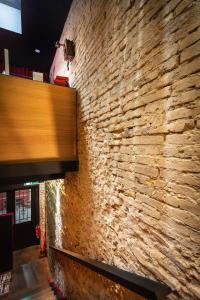 - un mur en pierre dans un restaurant avec un mur en briques dans l'établissement Zrooms&Suites Hostel Boutique, à Saragosse