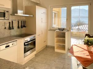 a kitchen with white cabinets and a table and a window at Villa Victoria in Hermagor